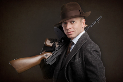 портрет гангстера в костюме, шляпе и с автоматом Томпсона