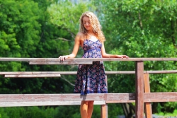 девушка в пестром платье на деревянном мостике над рекой